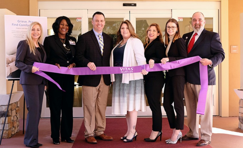 The VITAS teams holds a ceremonial purple ribbon