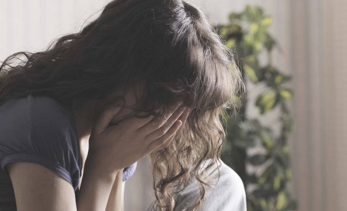 A grieving woman rests her head in her hands